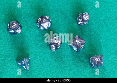 Set di grigio dadi poliedrica per Dungeons and Dragons gioco da tavolo a giocare sul green baize tabella Foto Stock