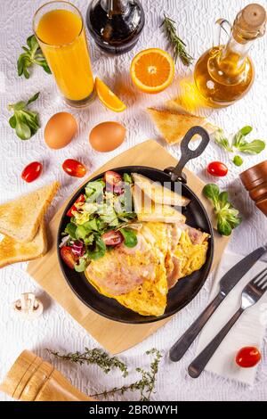 Prosciutto e frittata di uova, deliziosa e semplice con un fresco e tostare il pane e insalata fresca servita con succo d'arancia fresco Foto Stock