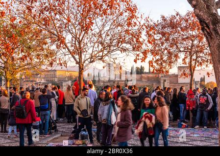 30 Novembre 2019 - Granada, Spagna. Turisti e gente del posto si riuniscono per godersi il bellissimo tramonto sul Palazzo dell'Alhambra, dal punto di vista di Mirado Foto Stock