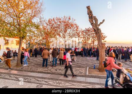 30 Novembre 2019 - Granada, Spagna. Turisti e gente del posto si riuniscono per godersi il bellissimo tramonto sul Palazzo dell'Alhambra, dal punto di vista di Mirado Foto Stock