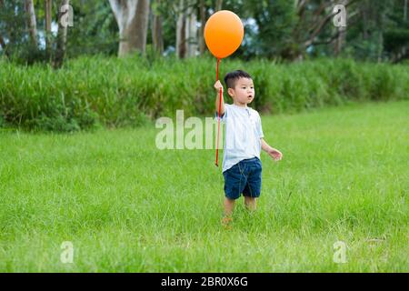 Little Boy di cattura con palloncino Foto Stock