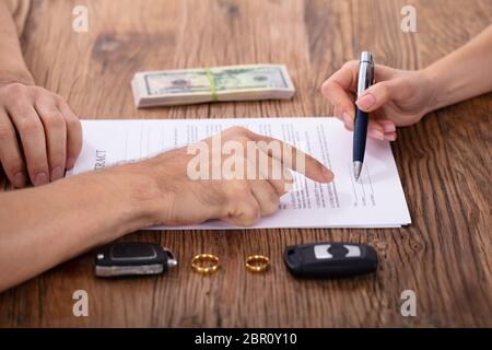 Giudice Client di assistenza nel riempire il modulo di appalto con coppia di anelli d oro Foto Stock