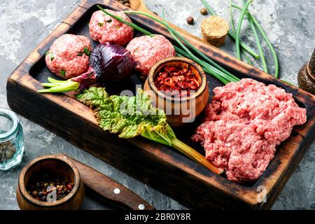 Crudo fresco carni bovine macinate sul tagliere e ingredienti Foto Stock