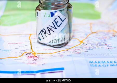 Composizione con banconote in denaro risparmiato in un vaso di vetro. Concetto di investimento e di mantenere i soldi per i sogni e i viaggi, primo piano isolato. Foto Stock