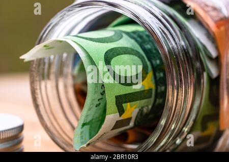 Composizione con banconote di risparmio in un vaso di vetro. Concetto di investimento e di mantenimento del denaro, primo piano isolato. Foto Stock