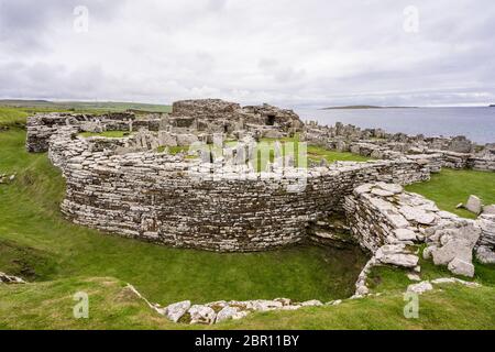 Architettura in pietra preistorica celtica con vista sull'oceano atlantico a Broch of Gurness in Aikerness Bay, Orkney Islands, Scozia Foto Stock