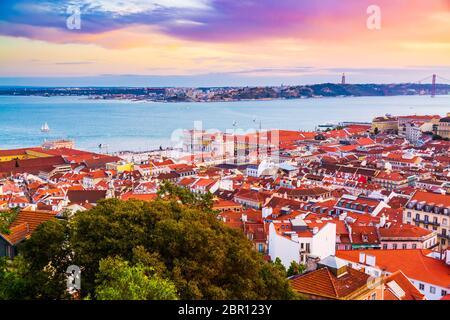 Bellissimo panorama del quartiere della città vecchia di Baixa e del fiume Tago nella città di Lisbona durante il tramonto, visto dalla collina del Castello di Sao Jorge, Portogallo Foto Stock
