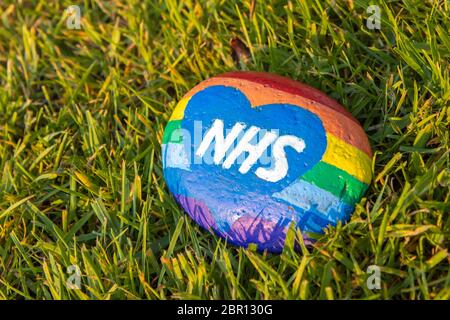 Tributo iridato NHS dipinto su una pietra durante la pandemia di Coronavirus Foto Stock