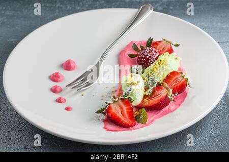 Frersh fragole con panna montata, di gelati e di zucchero in polvere . Foto Stock