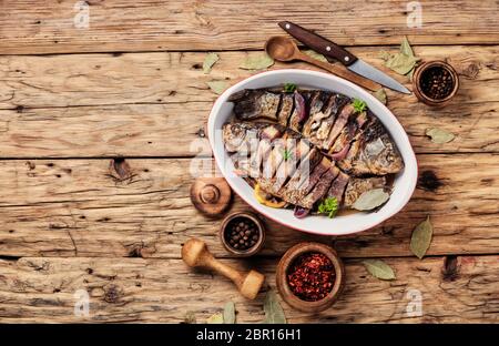 Pesce al forno caricato con gli agrumi, le erbe e le spezie nel pesce al forno Foto Stock