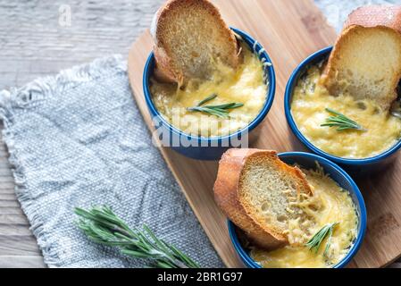 Ciotole di zuppa di cipolla sul pannello di legno Foto Stock