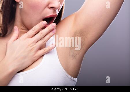 Close-up di una giovane donna con Hairy ascella Foto Stock
