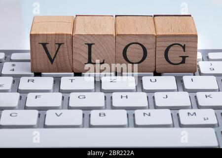 Close-up del blocco di legno con Vlog testo bianco su tastiera Foto Stock