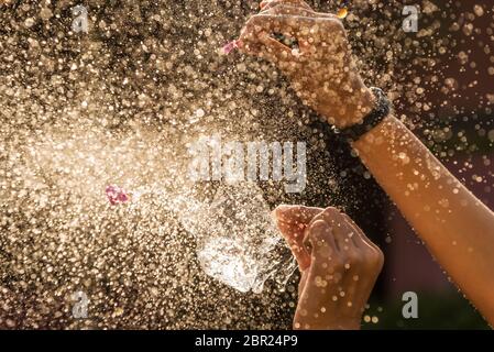 Mano di ragazza con spruzzi d'acqua su sfondo nero filtro scuro stile Foto Stock