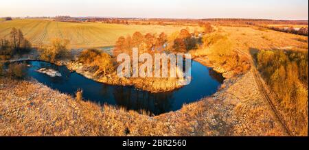 Luminosa alba sul selvaggio fiume curva vista aerea. Paesaggio fluviale in presenza di luce solare dal di sopra. Bielorussia Foto Stock