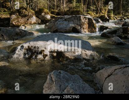Le grandi rocce in un torrente di montagna in Baviera con la foresta in background Foto Stock