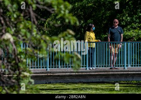 Londra, Regno Unito. 20 Maggio 2020. Ci sono ancora alcuni turisti sul ponte - alcune maschere di wwear, la maggior parte non. Godendo il sole nel parco di St James mentre il sole esce di nuovo. Il "blocco" continua per l'epidemia di Coronavirus (Covid 19) a Londra. Credit: Guy Bell/Alamy Live News Foto Stock