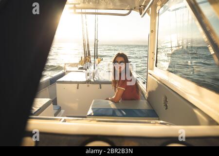 Una ragazza caucasica adolescente che si diverte a bordo di una barca Foto Stock