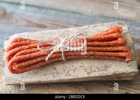 Salsicce affumicate sullo sfondo di legno Foto Stock