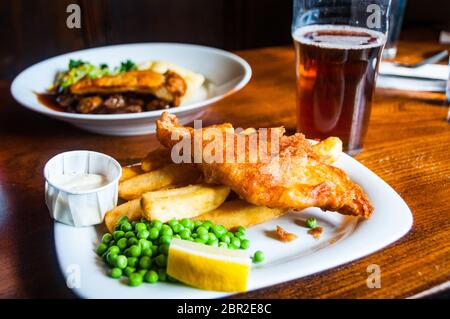 Un tradizionale pub Inglese con farina di pesce e patatine e una bistecca e torta di funghi lungo con una pinta di amaro. Foto Stock