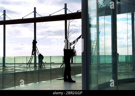 Sagome dei lavoratori pulizia vetro costruzioni presso il punto di vista moderno, Paphos, Cipro Foto Stock