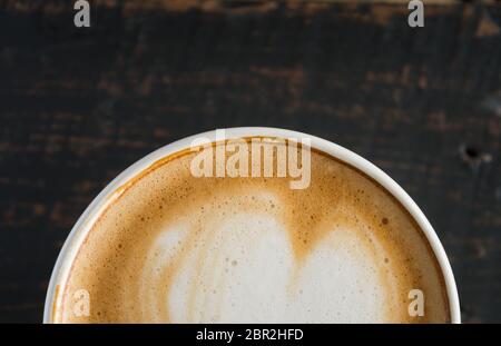 Flatlay fondo metà forma di cuore Latte Latte Art in bianco con tazza di caffè nero sulla tavola di legno. Forma di cuore Latte Latte Art bevanda calda per caffè Foto Stock