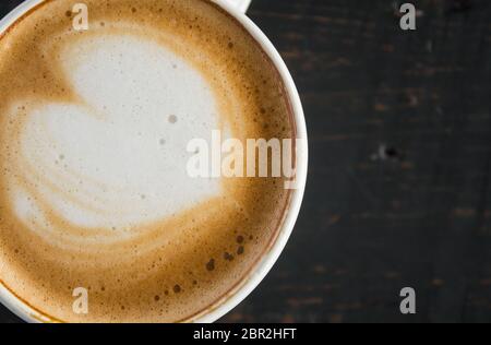 Flatlay metà forma di cuore Latte Latte Art in bianco con tazza di caffè nero sulla tavola di legno. Forma di cuore Latte Latte Art bevanda calda per amante del caffè Foto Stock