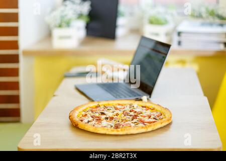 Concetto di business o studio. La pizza si trova su un tavolo in un caffè. Foto Stock