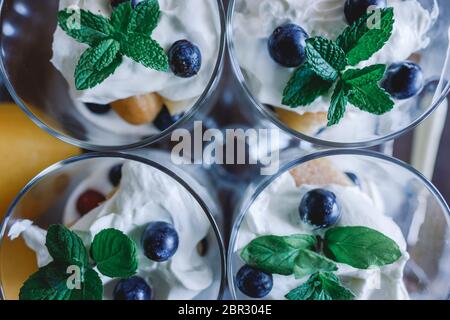 Tiramisù fatto in casa con limoni serviti a tavola. Vista dall'alto del delizioso dessert in tazze di vetro. Foto Stock