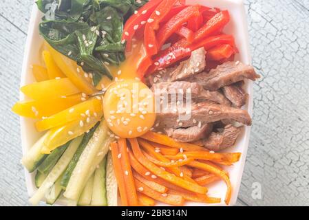 Ciotola di bibimbap sul tavolo di legno Foto Stock