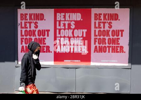 Shawlands, Glasgow, Scozia, Regno Unito. 20 maggio 2020. Una giovane donna cammina da un 'essere gentile. Guardiamo fuori per il segno un altro in Shawlands, Glasgow, Scotland Credit: Kay Roxby/Alamy Live News Foto Stock