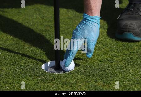 Una palla è tenuta per mostrare nuove misure sul posto per fermare la palla che cade a fondo di buco dopo il direttore di Green Keeping a St Andrews Links Trust Sandy Reid ha tagliato un buco sul 17 ° verde sul vecchio corso a St Andrews. Il primo ministro Nicola Sturgeon annuncerà una "mappa delle rotte" per il sollevamento del blocco del coronavirus in Scozia giovedì Foto Stock