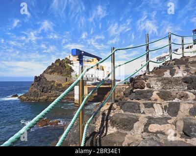 Vista sul piccolo villaggio di pescatori El Pris, sull'isola delle Canarie di Tenerife, situato in una posizione pittoresca sull'acqua, in parte su rocce laviche Foto Stock