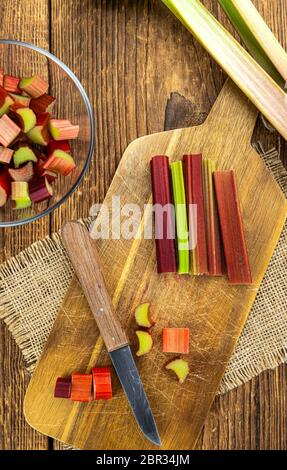 Rabarbaro tritato su un vecchio tavolo di legno (colpo di primo piano; fuoco selettivo) Foto Stock