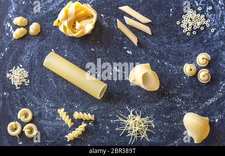 Vari tipi di pasta su sfondo scuro Foto Stock