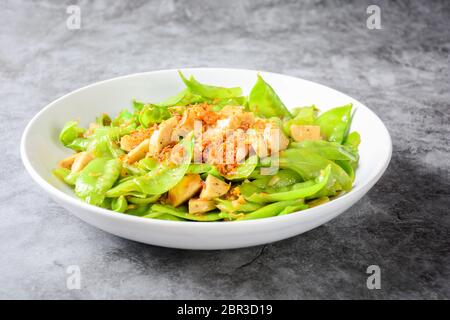 Friggere i piselli della neve con il vietnamita grigliate di salsicce di maiale, topping con croccante frittura di scalogni e garlics Foto Stock