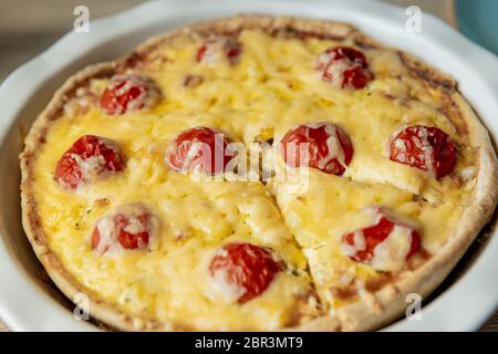 Quiche lorraine fatte in casa con pollo, pomodori e formaggio. Cucina francese. Messa a fuoco selettiva. Vista dall'alto. Spazio di copia Foto Stock