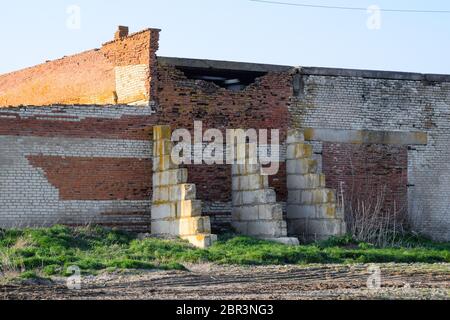 Vecchio mattone sovietica edificio abbandonato. Collassare costruzione in mattoni. Il bianco e il rosso mattone Foto Stock