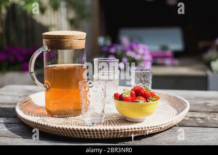 Fresca limonata fatta in casa con fragole all'aperto sul tavolo da giardino in estate colorato Foto Stock