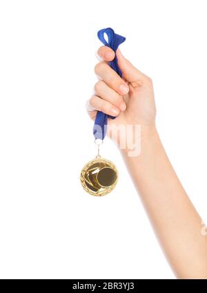 Ragazza mano alzata holding medaglia d oro contro uno sfondo bianco award e il concetto di vittoria Foto Stock