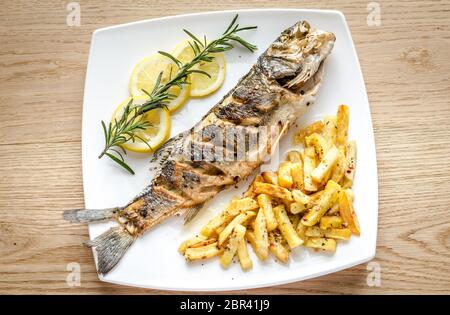 Branzino al forno con patate fritte Foto Stock