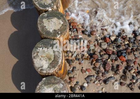 Buhnen con pietre lavate sulla spiaggia del Mar Baltico nella località balneare di Zempin su Usedom Foto Stock