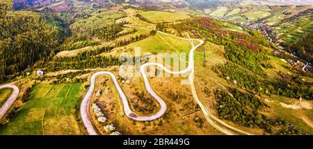 Piegatura curva strada a serpentina sulle colline. Avvolgimento strada alpina in montagna. Carpazi, Ucraina Foto Stock