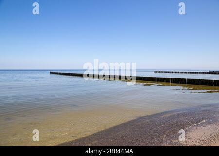 Groynes nel Mar Baltico con piccole onde nella località balneare di Zempin sull'isola di Usedom Foto Stock