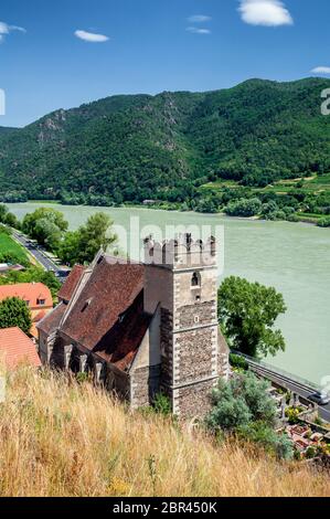 Pietra fortificata, la chiesa di St Michael, accanto al fiume Danubio in Weissenkirchen, nella valle di Wachau Foto Stock