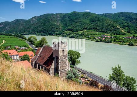 Pietra fortificata, la chiesa di St Michael, accanto al fiume Danubio in Weissenkirchen, nella valle di Wachau Foto Stock