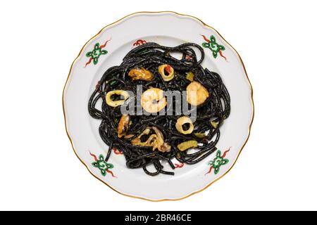 Vista dall'alto della pasta italiana nera con pesce. Closeup di noodle nere mediterranee con inchiostro seppie, cozze e gamberi isolati su una colorata p Foto Stock