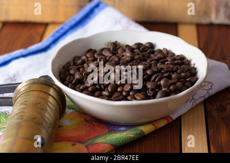 Il caffè pronto per essere lavorato con il vecchio macinino. Il caffè è nella tabella Foto Stock