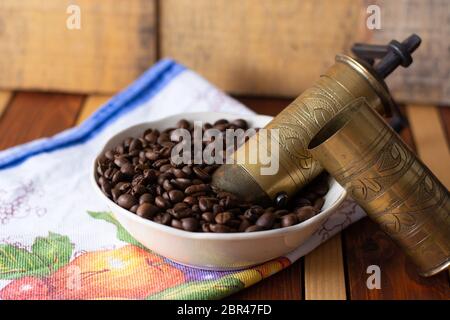 Il caffè pronto per essere lavorato con il vecchio macinino. Il caffè è nella tabella Foto Stock