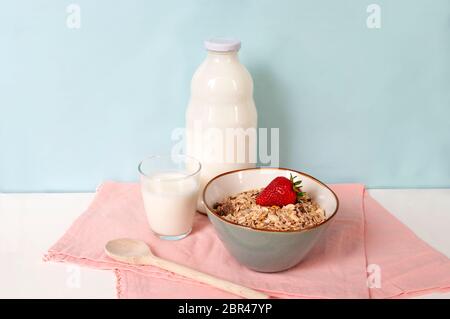 Colazione sana con latte, muesli e frutta. Spazio di copia. Su sfondo blu. Foto Stock